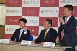 生体モニターをかざす伏見隆市長（左）と木村穣教授（右）