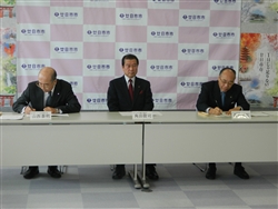 協定書に署名するイズミの山西社長（写真左）